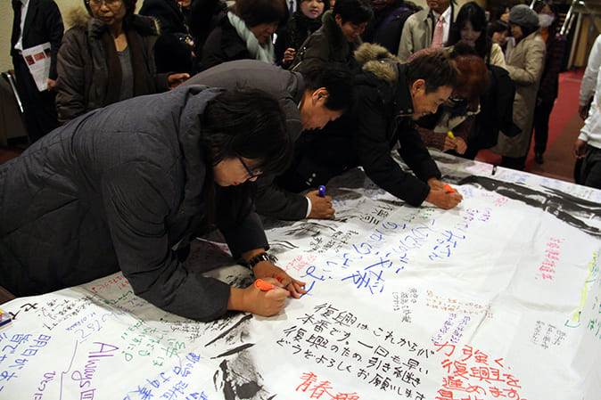Concert goers were given the opportunity to write messages for people in the stricken areas on “Wa” flags