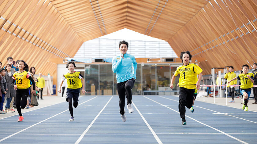 50メートルレース対決する子供たちと山縣亮太選手 写真