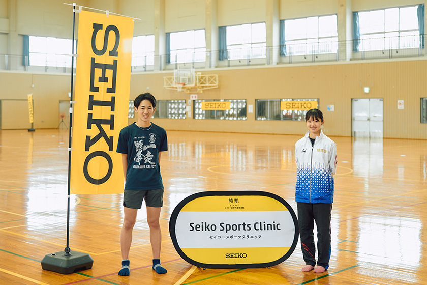 SEIKOの看板の横に並んでいる生徒　写真