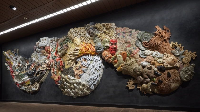 A dynamic composition consisting of 168 pieces: 164 ceramic panels and four bronze elements