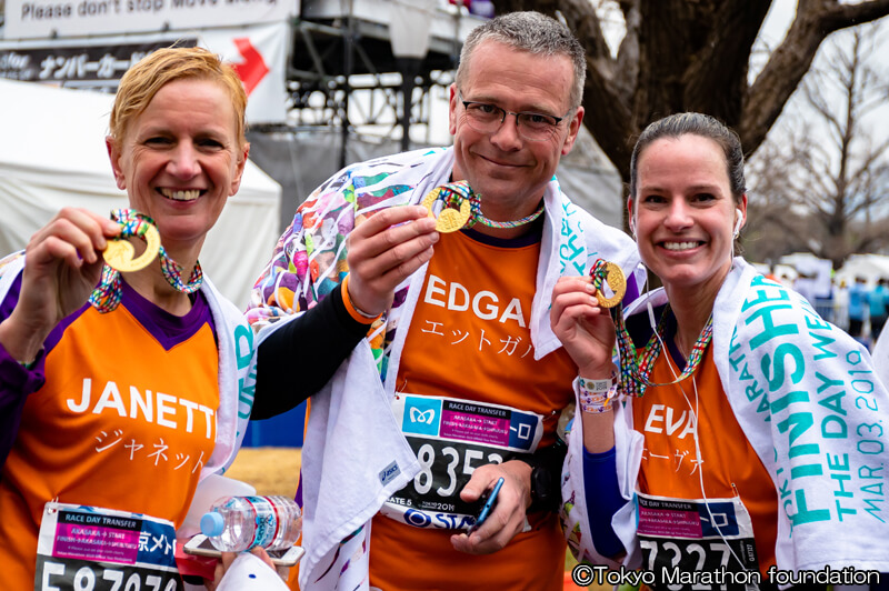 メダルを手に持ち笑顔の3人組、外国人ランナー　写真