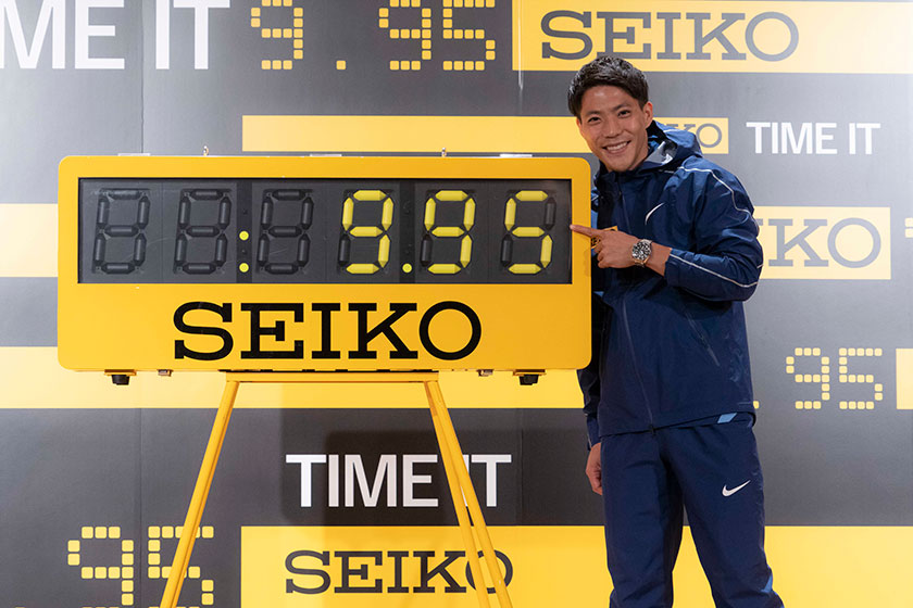 9秒95で男子100mの日本記録を更新し、セイコーのタイマーの前で笑顔を見せる山縣　写真