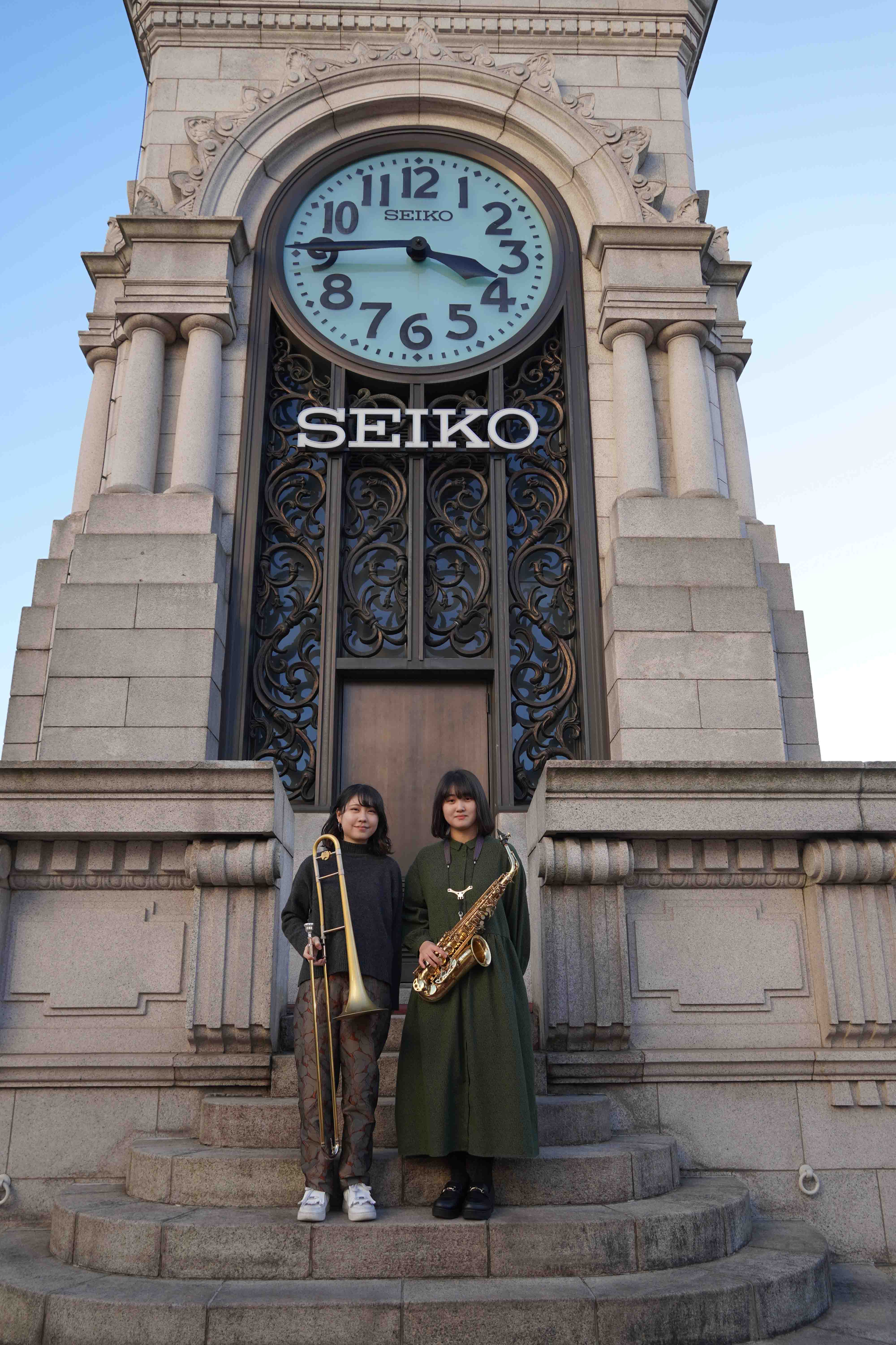 時計塔の前に並ぶ治田七海さんと佐々木梨子さん