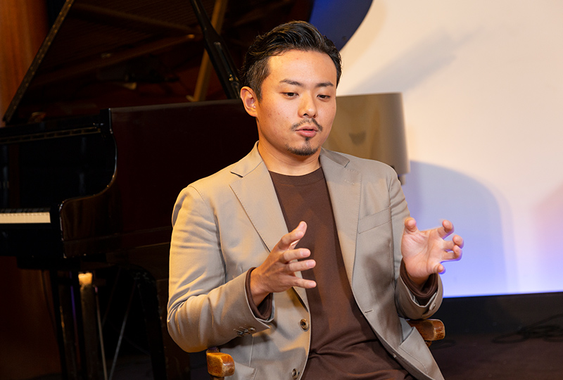ピアノを背景にして話す大林武司さん