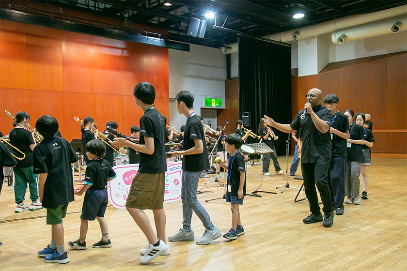 クインシーを先頭に歩きながら生徒たちが演奏する様子