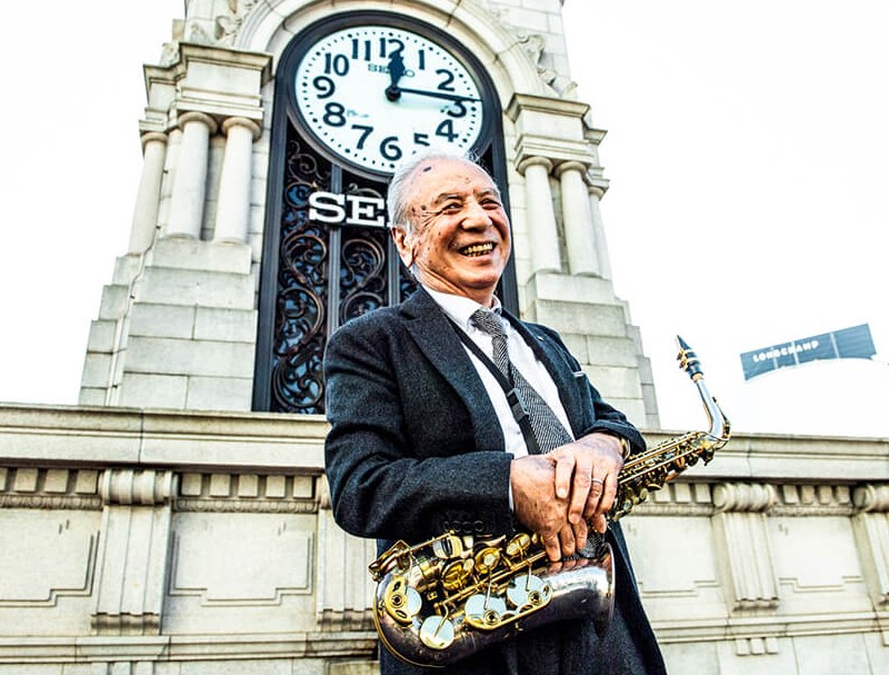 時計塔の前にいる渡辺貞夫さん