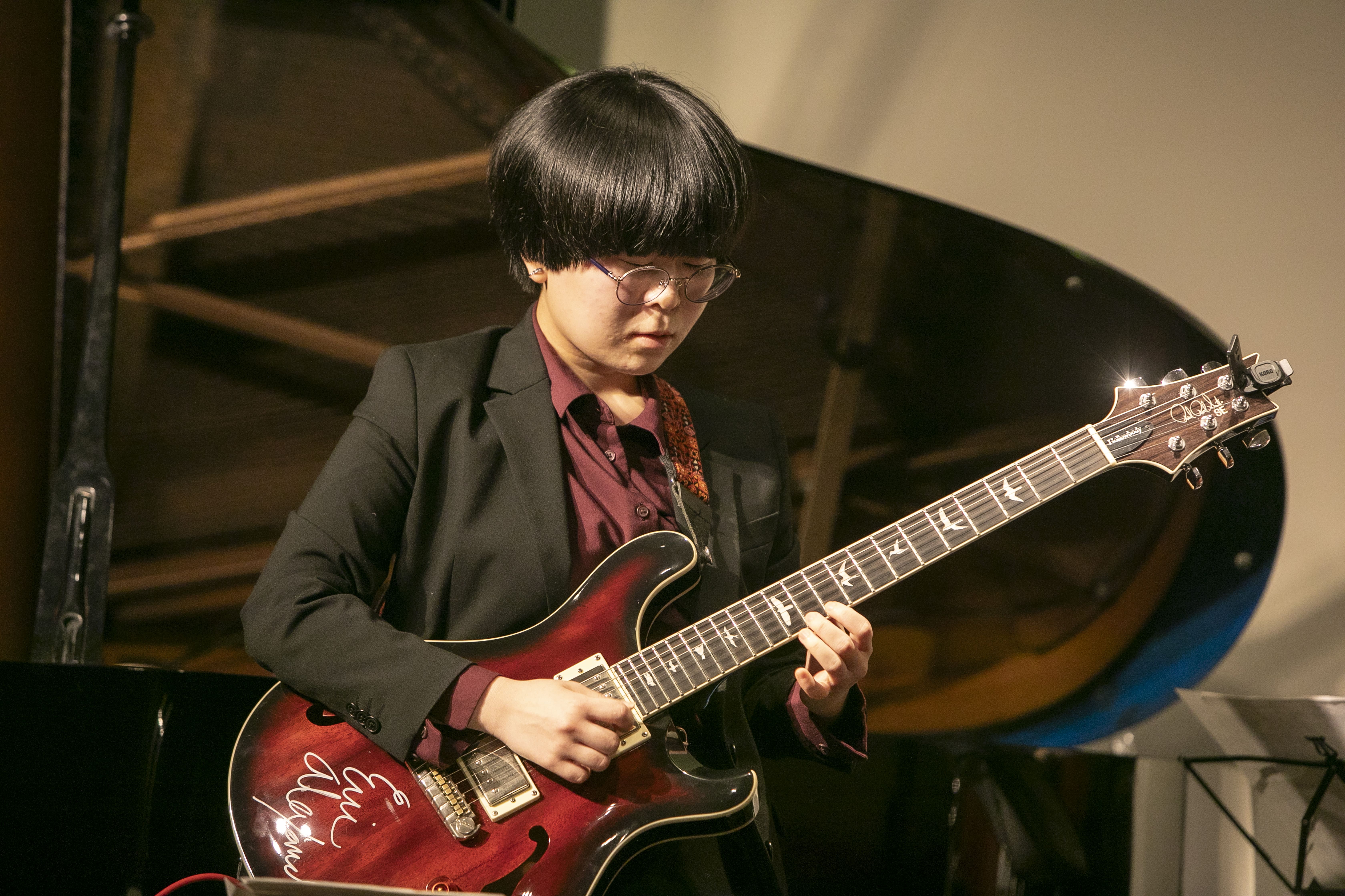 ギターを弾く堀田美紗子さん