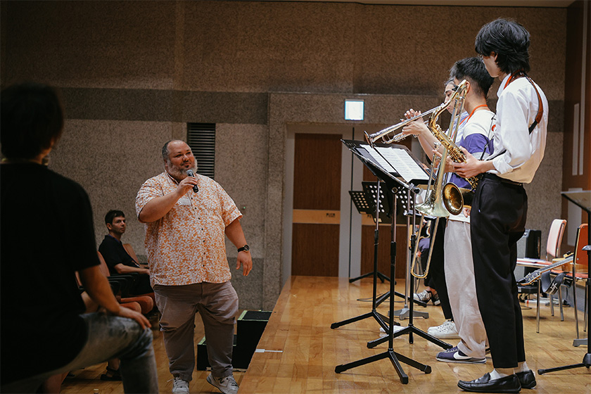 朗らかにレッスンするマイケルと真剣に話を聞く生徒たちの様子