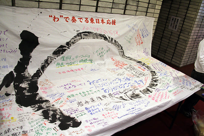 Concert goers were given the opportunity to write messages for people in the stricken areas on “Wa” flags